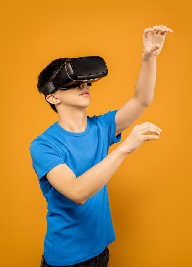 Man in Blue Crew Neck T-shirt Wearing Black VR Goggles